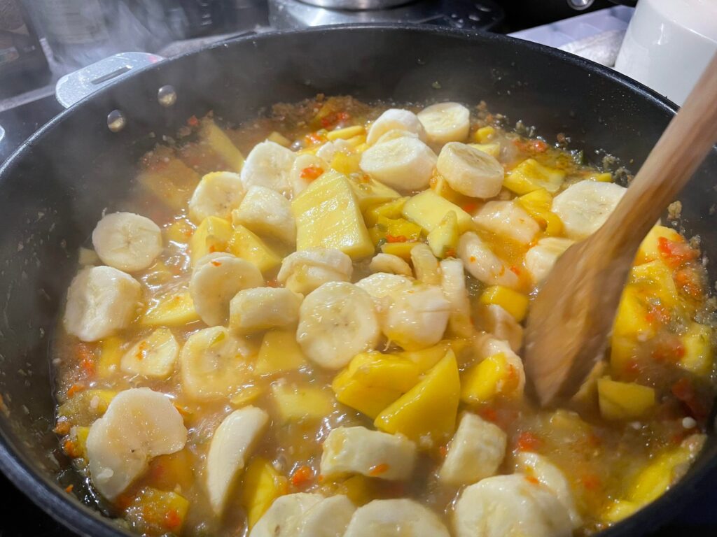 バナナとマンゴーをトウガラシ等と共に煮詰める写真