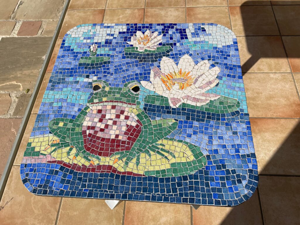 タイルでカエルとハスの花のデザインを施したテーブルの写真